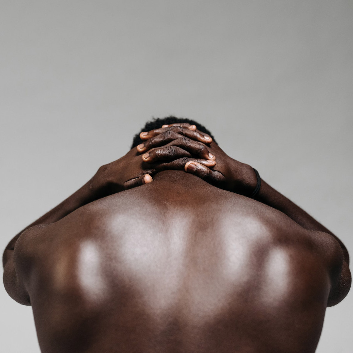 Man's back with hands behind head